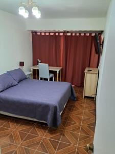 a bedroom with a bed and a table and a desk at Céntrico Depto - Viña del Mar in Viña del Mar