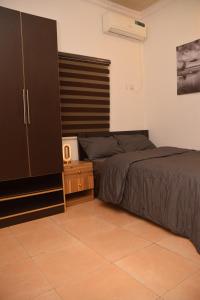 イケジャにあるAgathos Apartmentのタイルフロアのベッドルーム1室(ベッド2台、キャビネット付)