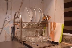イケジャにあるAgathos Apartmentのキッチンカウンターの上に皿とグラスが置かれたラック