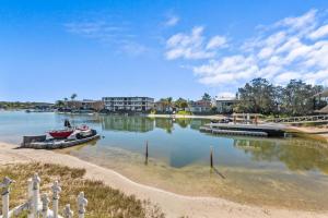 a boat is docked at a dock in the water at Family-Friendly Flat with Balcony Views in Mooloolaba