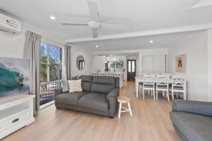 a living room with a couch and a dining room at Family-Friendly Flat with Balcony Views in Mooloolaba