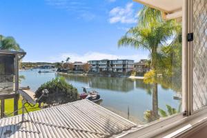 a view of a river from a house window at Family-Friendly Flat with Balcony Views in Mooloolaba +14 photos