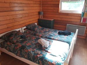 a bedroom with two beds in a log cabin at Gites des Abbayes in Le Mesnil-sous-Jumièges +2 photos
