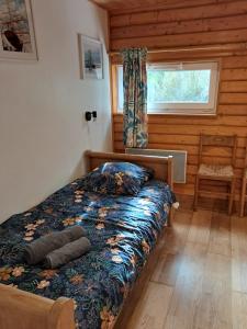 a bedroom with a bed in a log cabin at Gites des Abbayes in Le Mesnil-sous-Jumièges