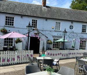 a white building with tables and chairs in front of it at Lavender Cottage, Welton in Welton