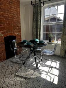 a dining room with a table and chairs and a fireplace at Lavender Cottage, Welton in Welton