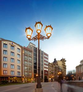 a street light on a city street with buildings at Hotel Campoamor in Oviedo