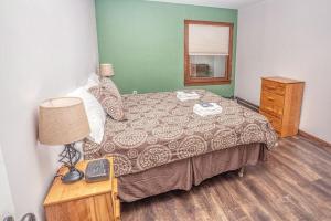 een slaapkamer met een bed en een tafel met een lamp bij Gateway Condo A25 in Mendon