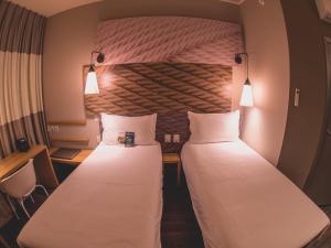 two beds in a hotel room next to each other at ibis Carlos Barbosa in Carlos Barbosa