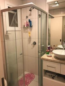 ein Badezimmer mit Glasdusche und Waschbecken in der Unterkunft Casa Tranquila - Condomínio Vila Verde Canela in Canela + 10 Fotos