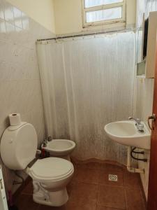 ein Badezimmer mit Toilette und Waschbecken in der Unterkunft Keóken a la vuelta del casino in Caleta Olivia