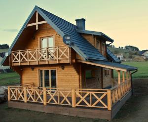 a log cabin with a gambrel roof at Dom Między Wzgórzami in Tylicz