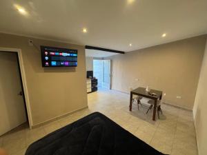 a living room with a piano and a television on the wall at Colon 533 Mono-Ambiente in Reconquista