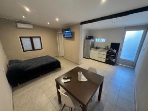 a room with a bed and a table and a kitchen at Colon 533 Mono-Ambiente in Reconquista