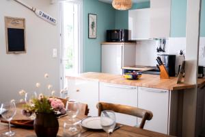 a kitchen with a wooden table and a dining room at Maison Harmonie entre Ocean et Nature in Saint-Jean-de-Monts