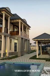 a villa with a guest house and a swimming pool at Verda in Shymkent