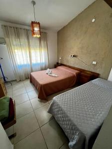 ヴィラ・カルロス・パスにあるHotel Suiza STのベッドが2つと窓があるホテルの部屋