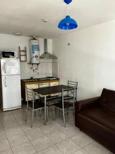 ヴィラ・カルロス・パスにあるHotel Suiza STのテーブルと椅子と冷蔵庫のあるキッチン