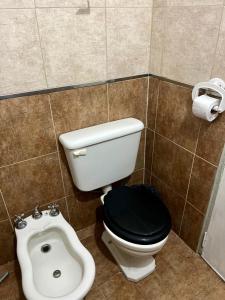 ヴィラ・カルロス・パスにあるHotel Suiza STの黒い便座とビデ付きのトイレを備えたバスルーム