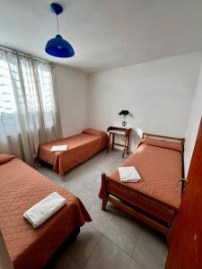 ヴィラ・カルロス・パスにあるHotel Suiza STのベッドが2つと青いライトのついたテーブルがある部屋 +28枚の写真