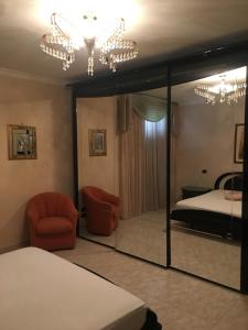 Un dormitorio con una cama, una silla y un espejo. en Brodolini, en San Donato di Lecce