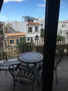 Una mesa y sillas en un balcón con vista. en Brodolini, en San Donato di Lecce