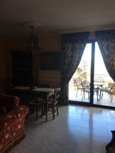 Una sala de estar con mesa y sillas y un balcón. en Brodolini, en San Donato di Lecce