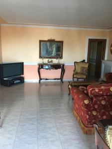 Una sala de estar con un sofá y un televisor. en Brodolini, en San Donato di Lecce