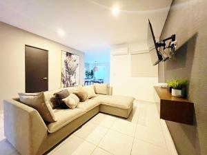 a living room with a couch in a room at Departamento Moderno Azul Cielo - 2 Albercas - 3 Min Malecón y Playas in Mazatlán