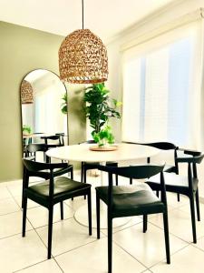 a dining room with a table and chairs and a chandelier at Departamento Moderno Azul Cielo - 2 Albercas - 3 Min Malecón y Playas in Mazatlán