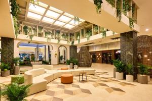 ココにあるRiu Guanacaste - All Inclusiveのソファと植物のある広いロビー