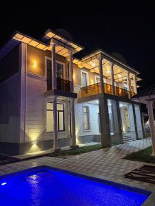 a house with a swimming pool in front of it at night at Verda in Shymkent