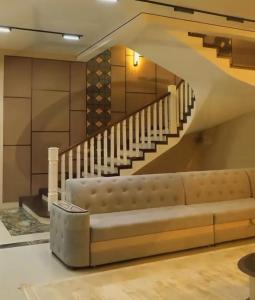 a living room with a couch and a staircase at Verda in Shymkent