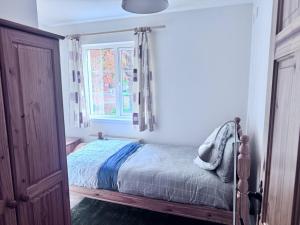 a bedroom with a bed and a window at Clones Town House in Cluain Eois