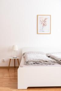 ein weißes Schlafzimmer mit einem Bett und einer Lampe in der Unterkunft Klidný apartmán v rodinném domě v blízkosti centra in Nový Jičín