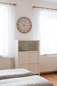 eine Uhr, die über einem Schlafzimmer an der Wand hängt in der Unterkunft Klidný apartmán v rodinném domě v blízkosti centra in Nový Jičín + 11 Fotos