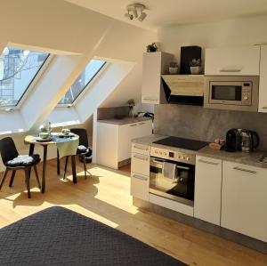 a kitchen with white cabinets and a table with a stove at Apartment with a terrace in Vienna