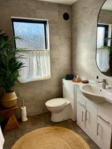 a bathroom with a toilet and a sink and a mirror at NEW! Stylish Chester Townhouse, Sleeps 6 in Chester