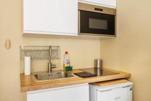 Una pequeña cocina con fregadero y microondas. en COMM - Proudhon 6 - SC - Séjour moderne à Besançon, en Besançon 5 fotos más
