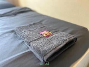 Una toalla gris sobre una cama en COMM - Proudhon 6 - SC - Séjour moderne à Besançon, en Besançon