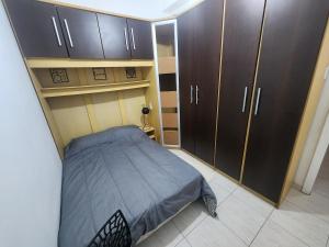 a bedroom with a bed and some brown cabinets at Sala e quarto a 1 quadra da praia de Copacabana in Rio de Janeiro