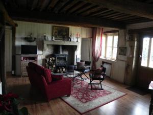 a living room with a red couch and a fireplace at Les Belins in Bourg-le-Comte
