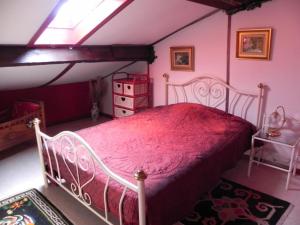 a bedroom with a bed with a red bedspread at Les Belins in Bourg-le-Comte +7 photos