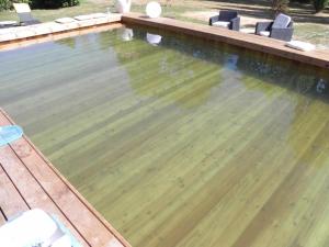 an empty swimming pool with a wooden deck at Les Belins in Bourg-le-Comte