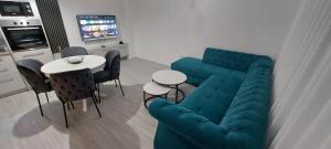 a living room with a blue couch and a table at Apartman Vaske 2 sa GARAŽOM in Brčko +35 photos