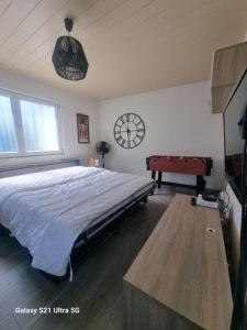 een slaapkamer met een bed en een klok aan de muur bij MAISON COSY 7 minutes des frontières in Rosenau +10 foto's