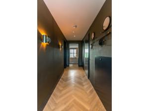 a hallway with black walls and a wooden floor at Modern villa in De Cocksdorp near the beach in De Cocksdorp +20 photos