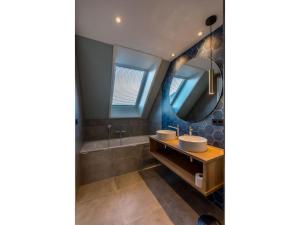 a bathroom with two sinks and a tub at Modern villa in De Cocksdorp near the beach in De Cocksdorp