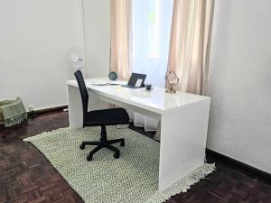 ein Büro mit einem weißen Schreibtisch und einem Stuhl in der Unterkunft Villa Herédia in Ribeira Brava
