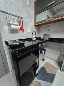 een keuken met een zwart aanrecht en een wastafel bij STÚDIO - Novo e Sofisticado! in Princesa dʼOeste